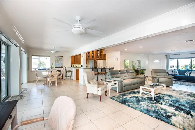 a living room with lots of tables a large window and chairs