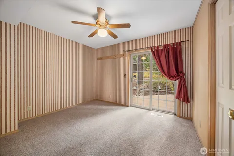 a view of a livingroom with a ceiling fan and window