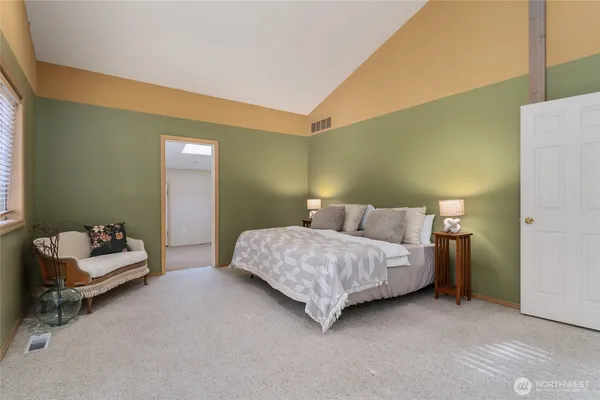 a bedroom with a large bed and a chandelier