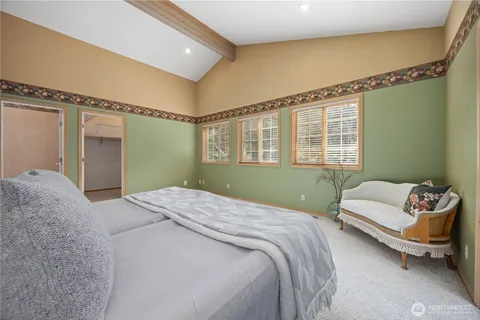 a bedroom with a bed couch and a window