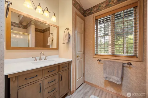 a en suite bathroom with a granite countertop sink mirror and a shower