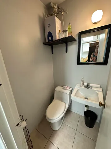 a bathroom with a toilet sink and mirror