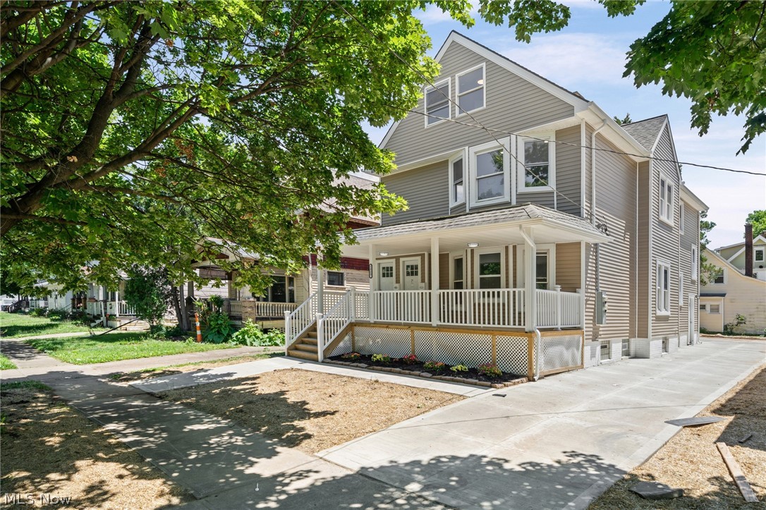 Two-story residence featuring light gray siding and white trim