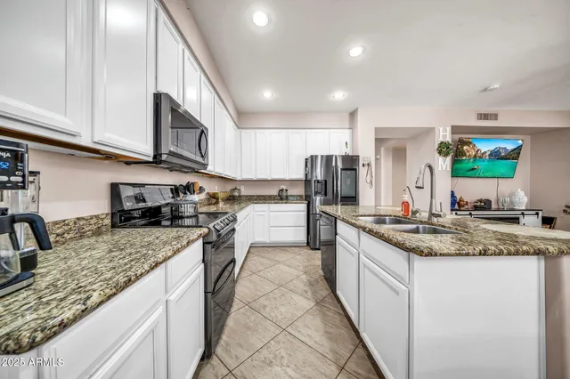 a kitchen with stainless steel appliances granite countertop a sink stove and cabinets