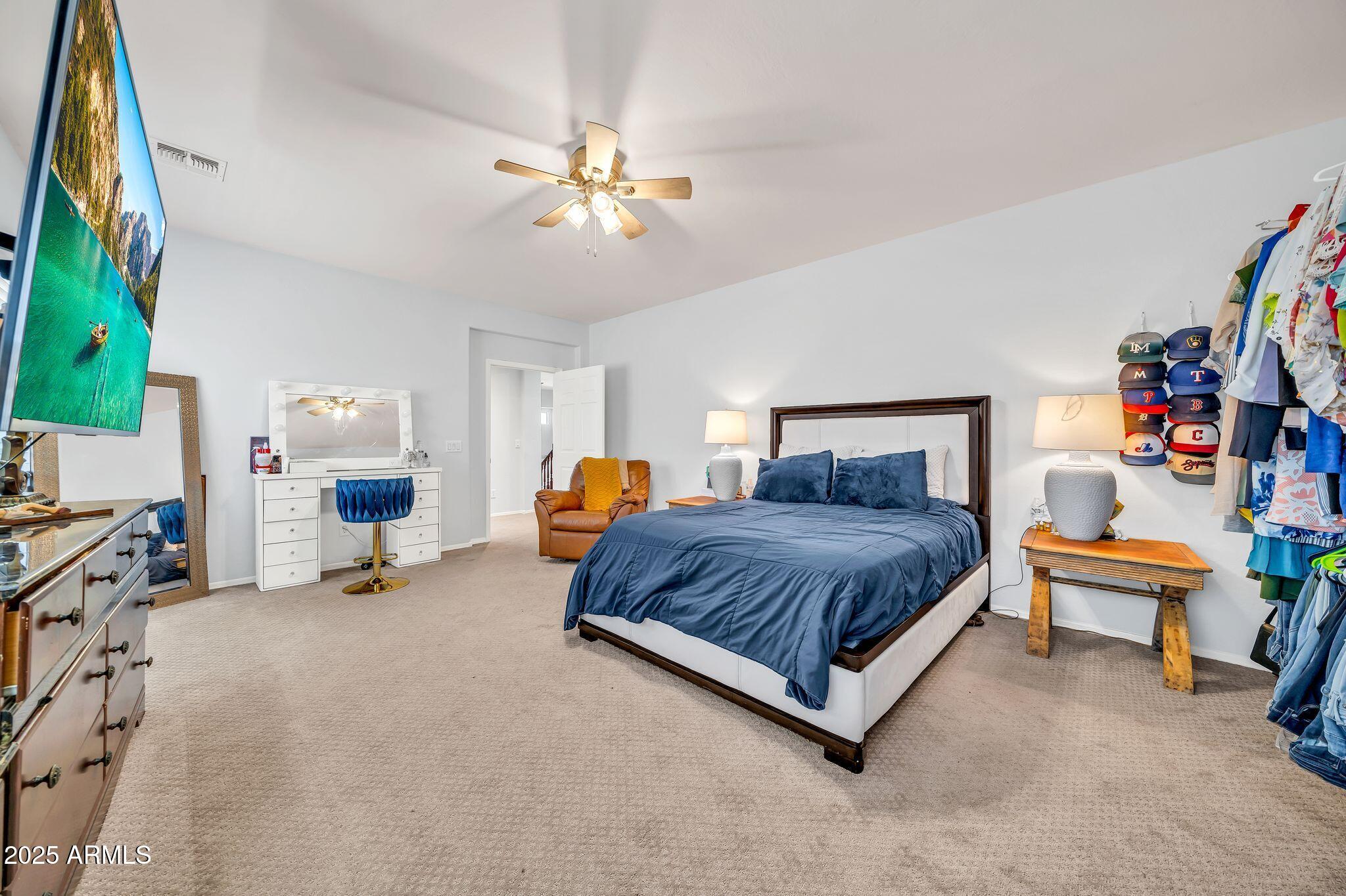 2292 South 155th Lane Goodyear, AZ 85338 - Photo 22 of 62 a spacious bedroom with a bed and a chandelier