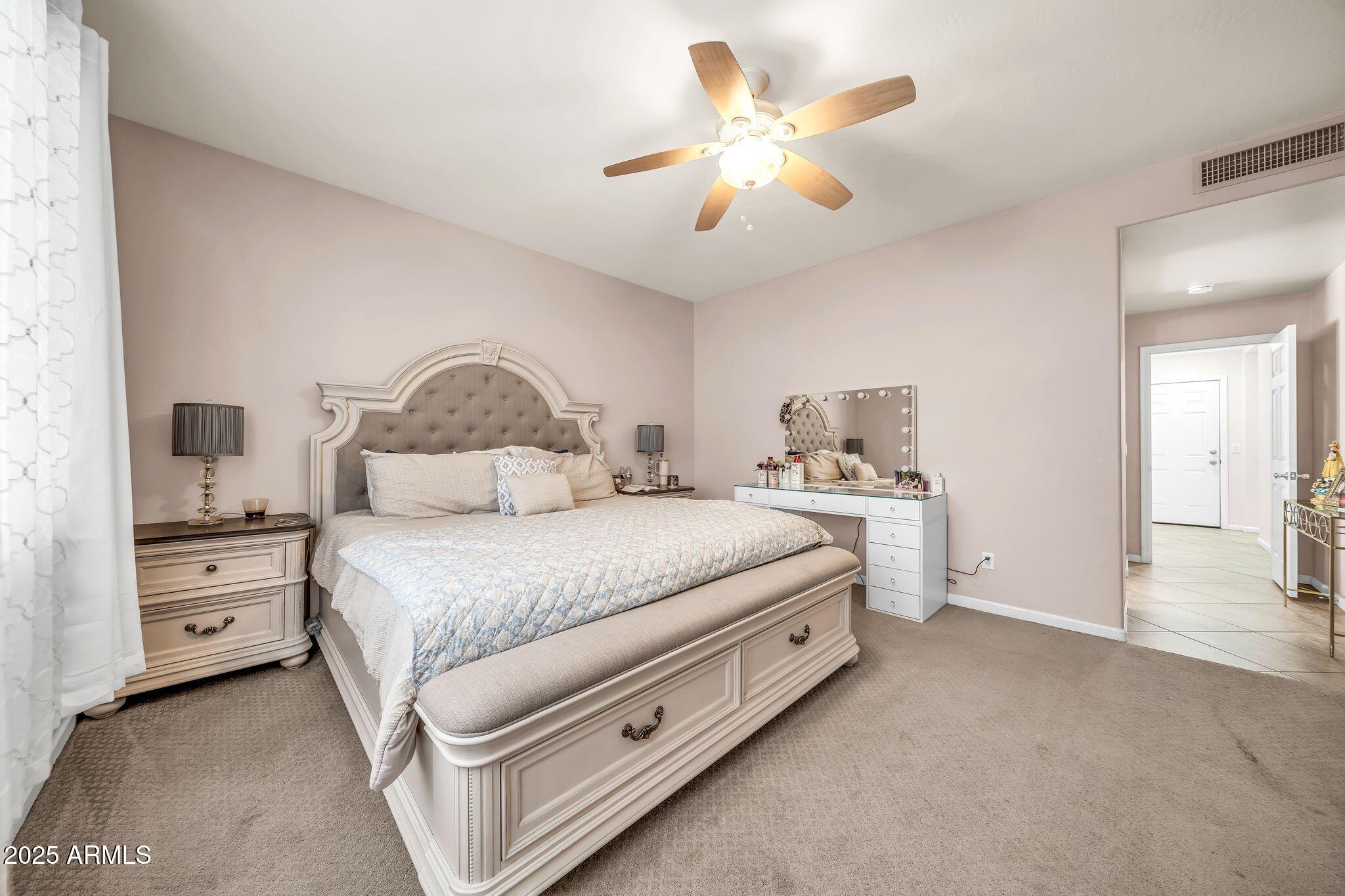 2292 South 155th Lane Goodyear, AZ 85338 - Photo 24 of 62 a bedroom with a bed and a chandelier