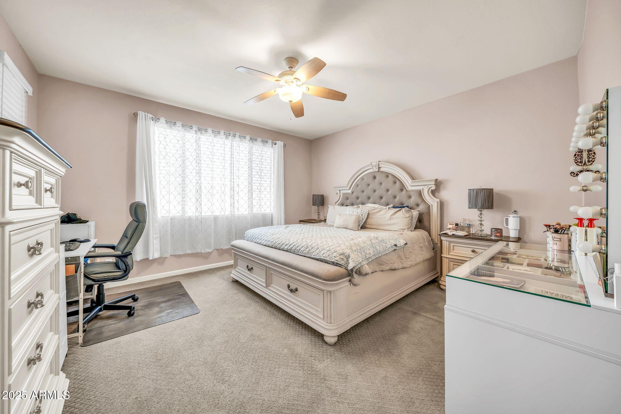 2292 South 155th Lane Goodyear, AZ 85338 - Photo 25 of 62 a bedroom with a bed a desk and chair with window