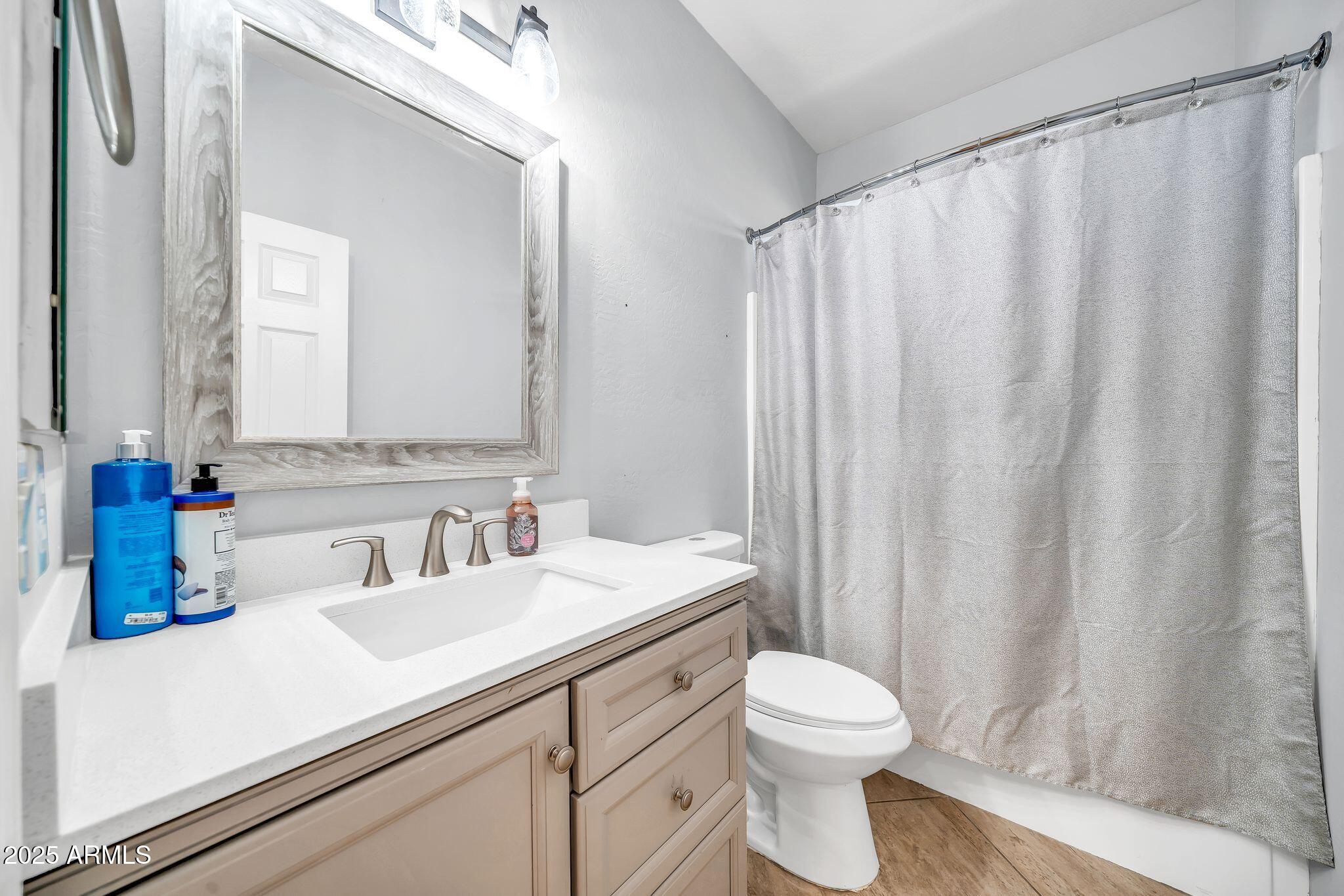 2292 South 155th Lane Goodyear, AZ 85338 - Photo 34 of 62 a bathroom with a sink a toilet and shower curtain
