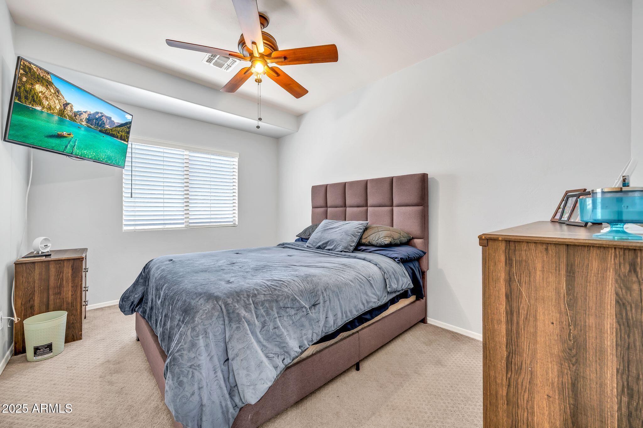 2292 South 155th Lane Goodyear, AZ 85338 - Photo 38 of 62 a bed sitting in a bedroom next to a window