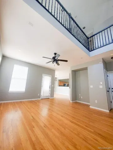 a view of an empty room with window and wooden floor