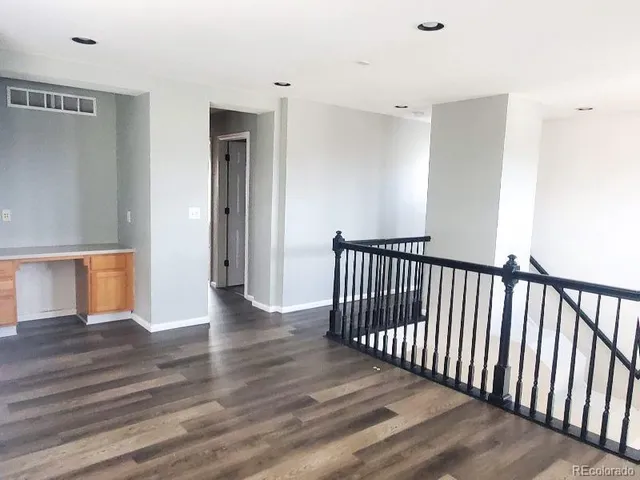 a view of a hallway with wooden floor