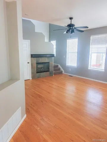 an empty room with windows and fireplace