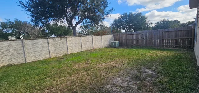 a view of a backyard with wooden fence