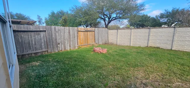 a view of a backyard with wooden fence