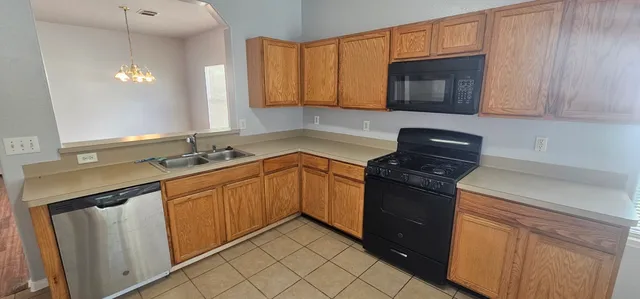 a kitchen with granite countertop cabinets stainless steel appliances and a sink