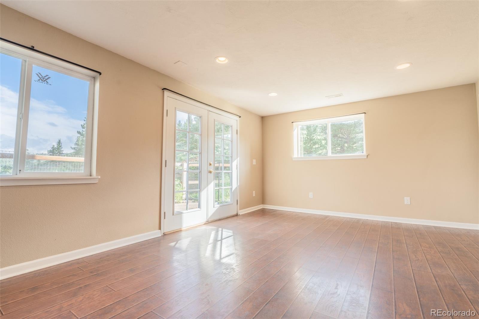 180 Deep Cut Road Livermore, CO 80536 - Photo 29 of 48 a view of an empty room with wooden floor and a window