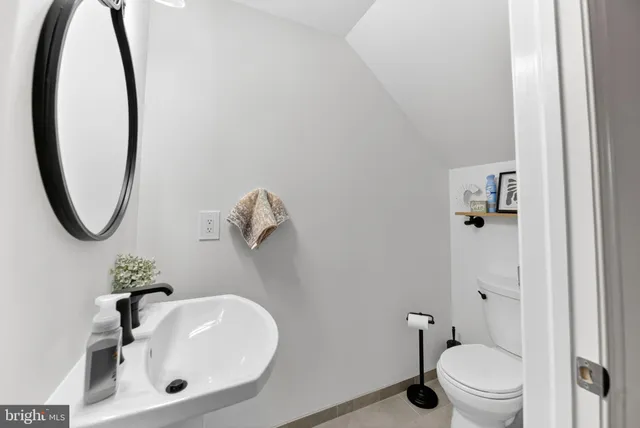 a bathroom with a sink toilet and a mirror