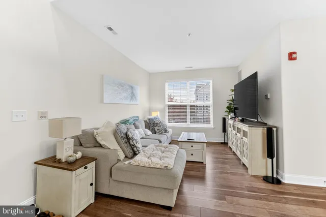 a living room with furniture a flat screen tv and a table