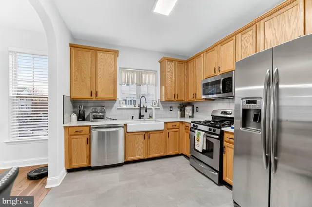 a kitchen with stainless steel appliances granite countertop a stove a sink dishwasher a refrigerator and a microwave oven