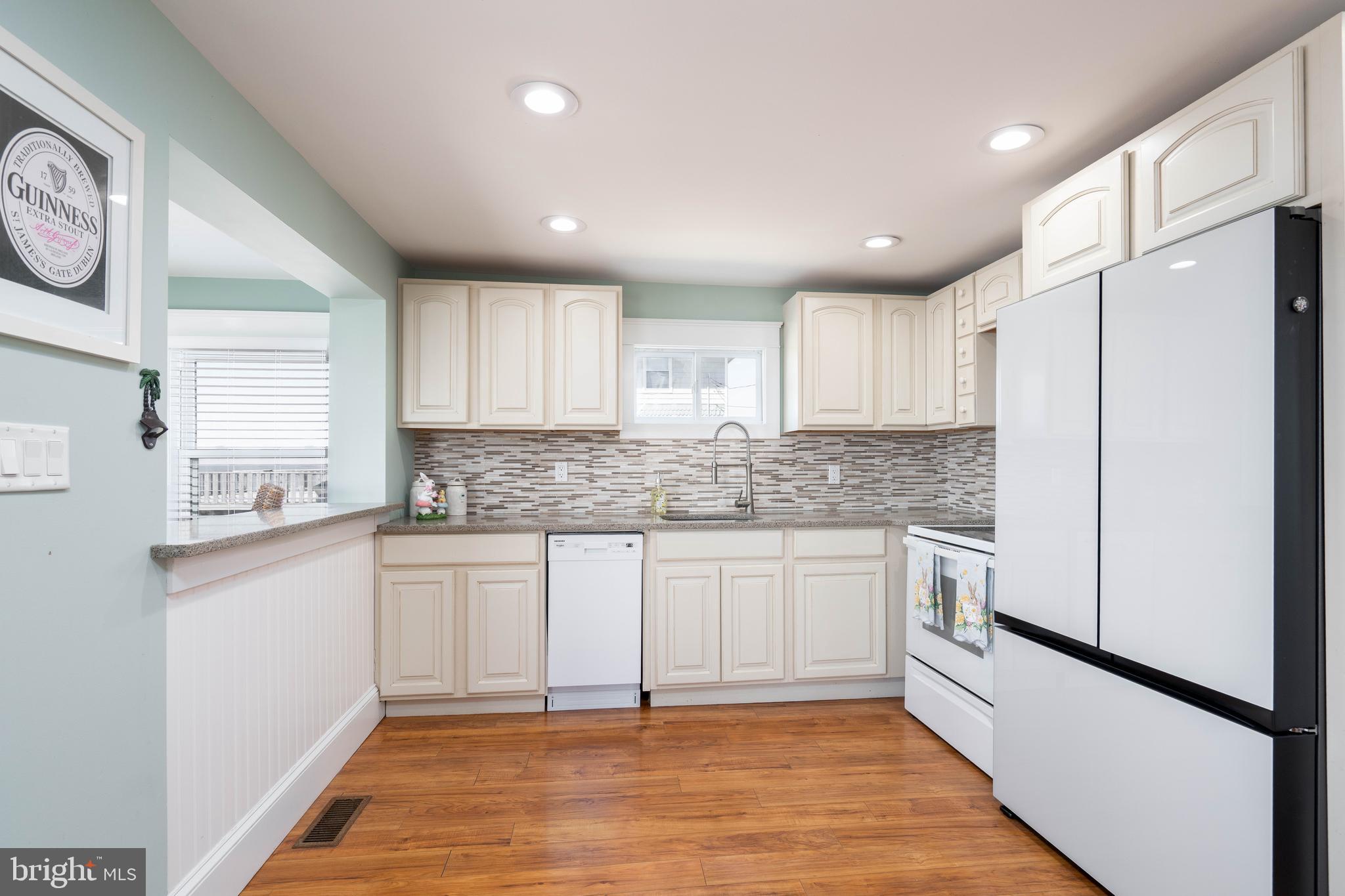 98 Delaware Avenue Fortescue, NJ 08321 - Photo 7 of 51 a kitchen with granite countertop a refrigerator a sink and white cabinets