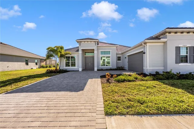a view of a house with a yard and potted plants