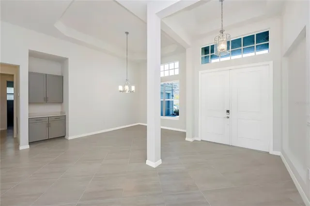 a view of an empty room with a window and a kitchen