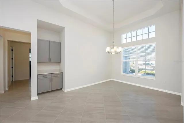 a view of an empty room and kitchen with furniture large window and kitchen view