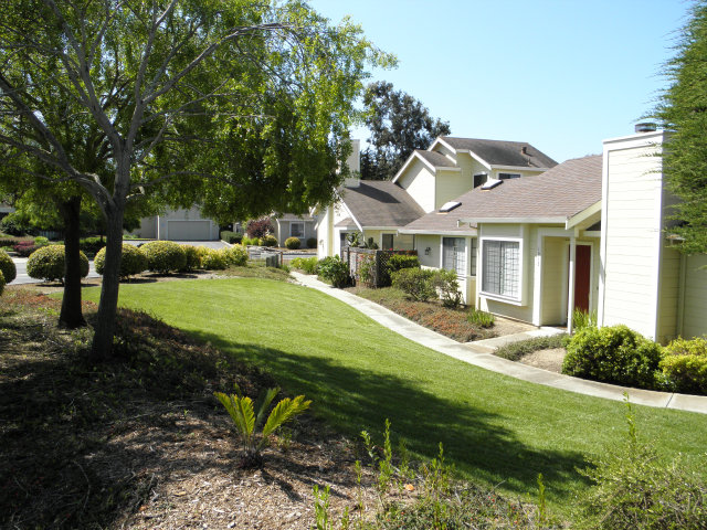 a view of a house with backyard and sitting area