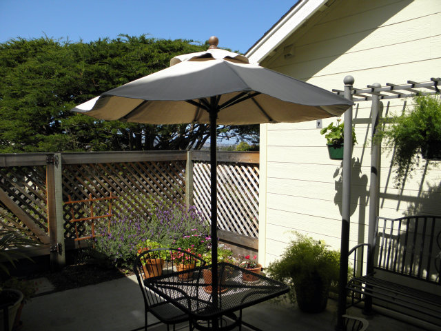 1031 Olympic Lane Seaside, CA 93955 - Photo 15 of 18 a view of a patio with table and chairs under an umbrella with wooden fence