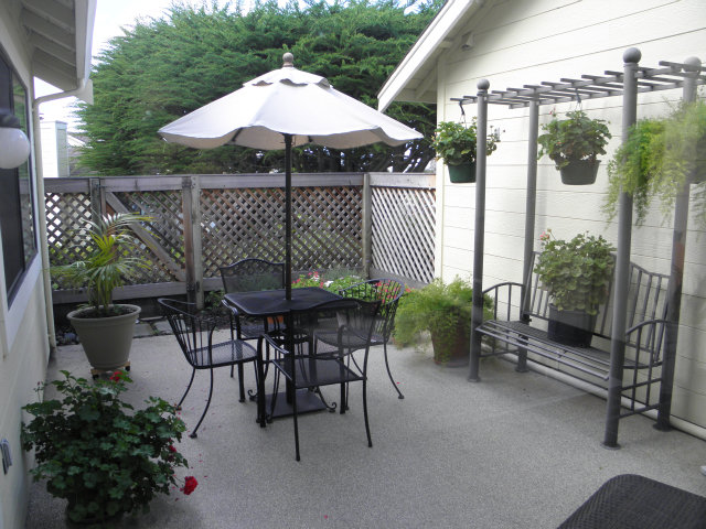 1031 Olympic Lane Seaside, CA 93955 - Photo 16 of 18 a patio with tables and chairs and a umbrella
