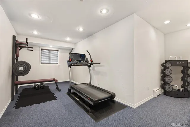 a room with gym equipment and a wooden floor
