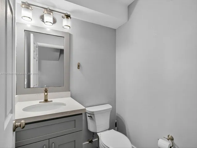 a bathroom with a sink mirror and toilet