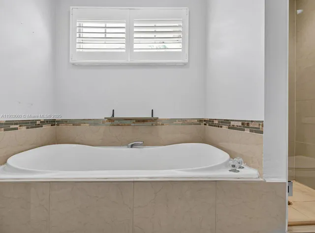 a bath tub sitting in a bathroom next to a window
