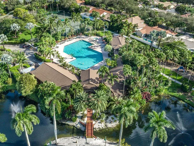 an aerial view of residential houses with outdoor space and trees