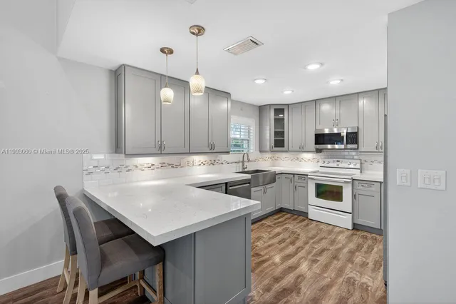 a kitchen with a sink stainless steel appliances and white cabinets