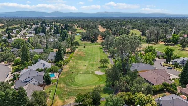 an aerial view of residential houses with outdoor space and trees