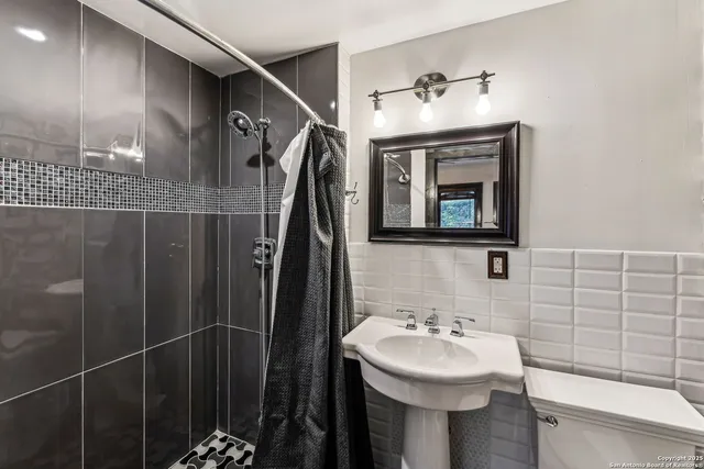 a bathroom with a sink and mirror with toilet
