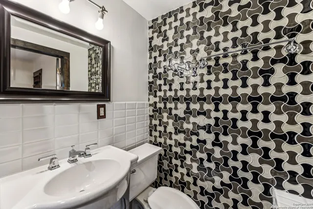 a bathroom with a sink toilet and mirror