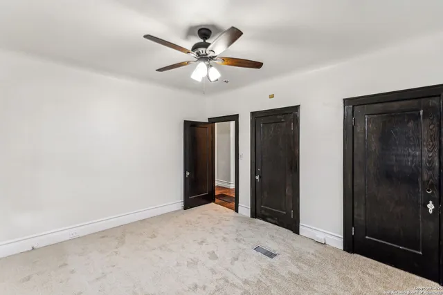 a view of an empty room with a ceiling fan