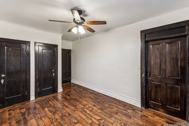 a bedroom with a bed and a chandelier fan