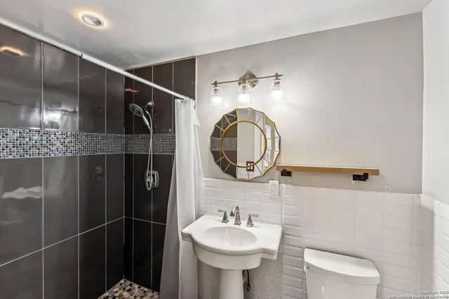 a bathroom with a sink a toilet and a mirror