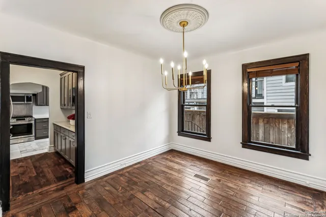 a view interior of a house wooden floor chandelier and windows