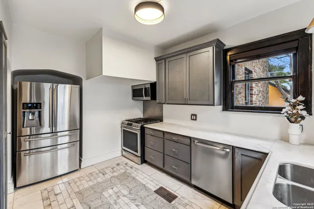 a kitchen with stainless steel appliances granite countertop a refrigerator sink and stove