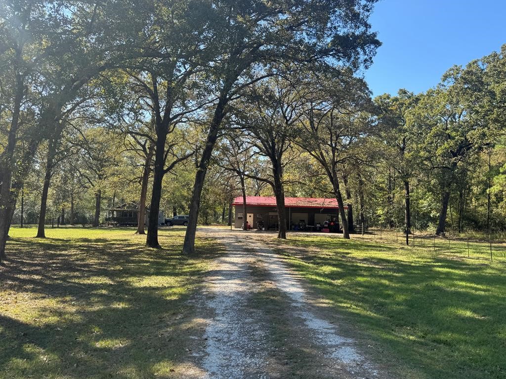 690 Jim Fenley Loop Lufkin, TX 75901 - Photo 1 of 22 a house with huge green field and trees in the background