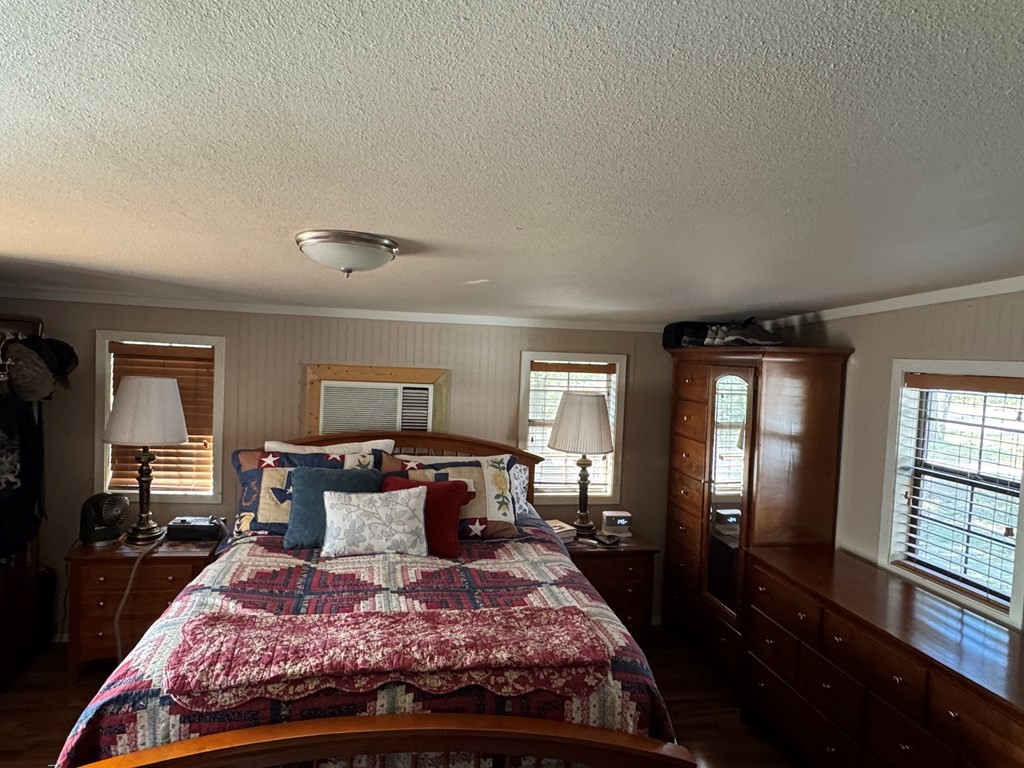 690 Jim Fenley Loop Lufkin, TX 75901 - Photo 18 of 22 a bedroom with a large bed and wooden floor
