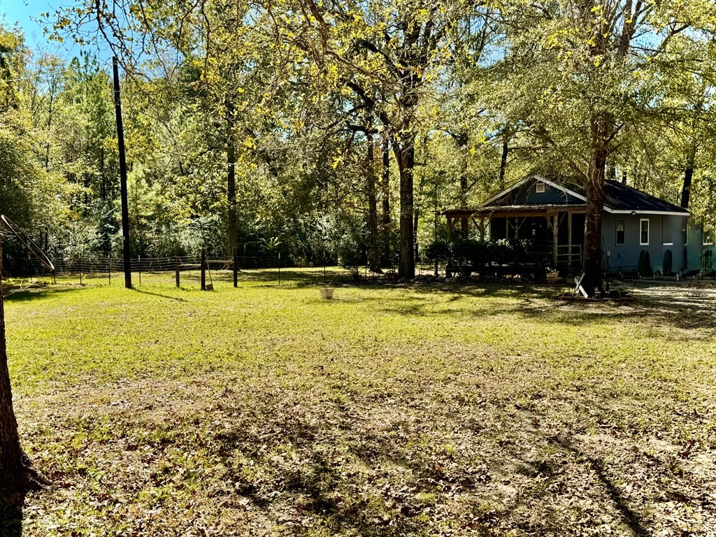 690 Jim Fenley Loop Lufkin, TX 75901 - Photo 5 of 22 a view of swimming pool with lawn chairs and large trees