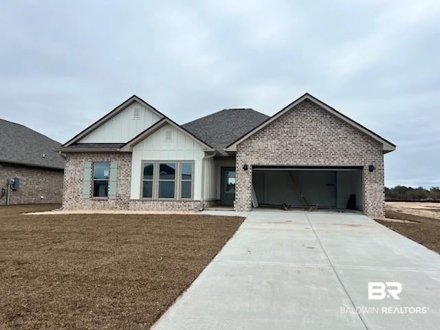 426 Raley Farms Drive Gulf Shores, AL 36542 - Photo 1 of 37 View of front facade featuring board and batten siding, driveway, a garage, and brick siding