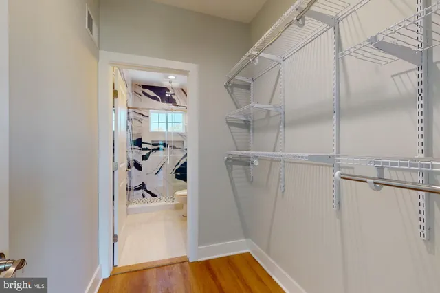 a view of walk in closet with clothes and shoes