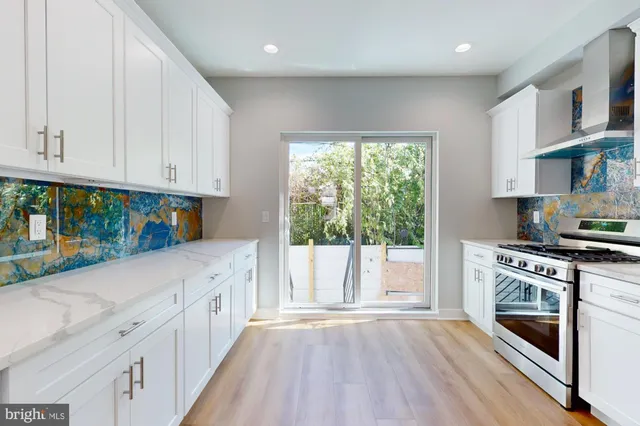 a kitchen with granite countertop a stove a sink and a refrigerator