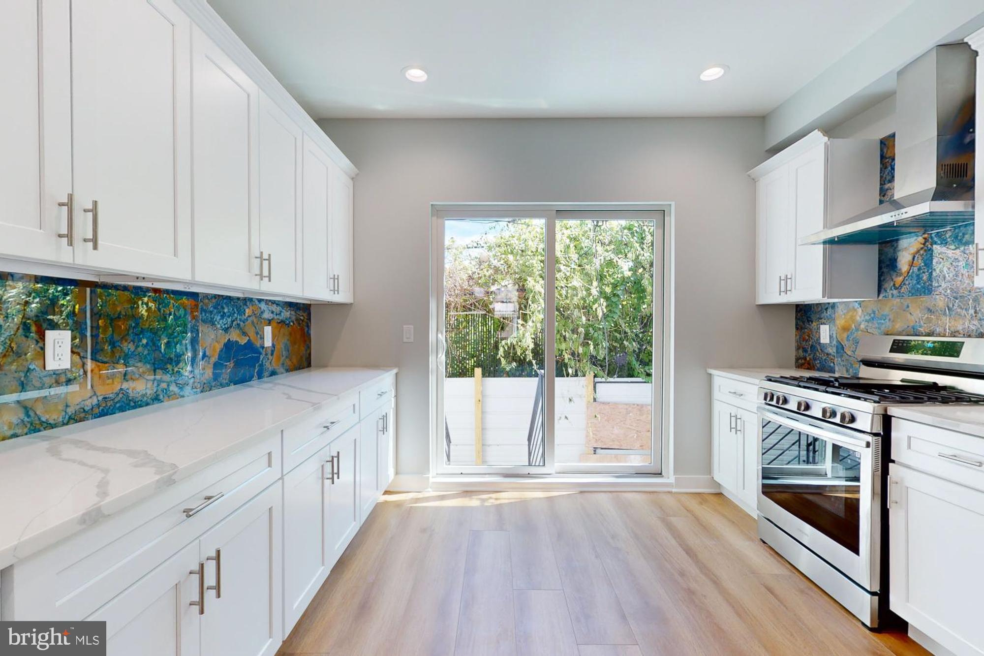511 North Paxon Street Philadelphia, PA 19131 - Photo 3 of 33 a kitchen with granite countertop a stove a sink and a refrigerator
